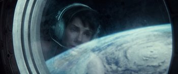 Movie still from “Gravity” (2013), directed by Alfonso Cuarón – A man wearing headphones in front of the earth; Close Up shot, Overhead angle