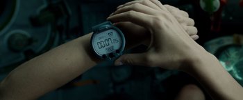 Movie still from “Gravity” (2013), directed by Alfonso Cuarón – A person is holding a watch in their hand; Extreme Close Up shot, High angle