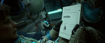 Movie still from “Gravity” (2013), directed by Alfonso Cuarón – A person holding a book in their hand; Close Up shot, Overhead angle
