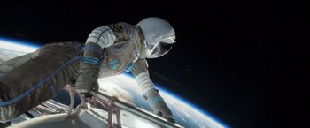 Movie still from “Gravity” (2013), directed by Alfonso Cuarón – An astronaut in a spacesuit standing in front of the earth; Wide shot, Overhead angle