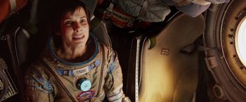 Movie still from “Gravity” (2013), directed by Alfonso Cuarón – A person in a space suit with a banana; Medium shot, Overhead angle
