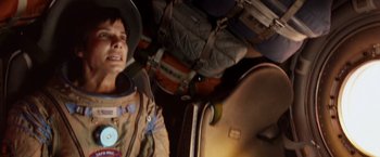 Movie still from “Gravity” (2013), directed by Alfonso Cuarón – A person in a space suit with a bunch of luggage in front of him; Medium shot, Overhead angle