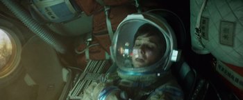 Movie still from “Gravity” (2013), directed by Alfonso Cuarón – A man in a space suit is looking at a computer screen; Medium shot, Overhead angle