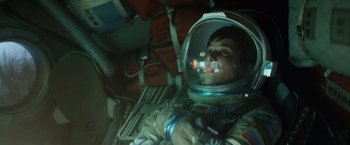 Movie still from “Gravity” (2013), directed by Alfonso Cuarón – A man in a spacesuit is looking at the camera; Medium shot, Overhead angle