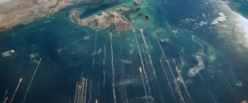 Movie still from “Gravity” (2013), directed by Alfonso Cuarón – An aerial view of a body of water with smoke coming out of it; Extreme Wide shot, Overhead angle