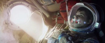 Movie still from “Gravity” (2013), directed by Alfonso Cuarón – A view of the inside of an airplane with a helmet on; Medium shot, Overhead angle