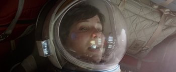 Movie still from “Gravity” (2013), directed by Alfonso Cuarón – A woman wearing a space suit in a space helmet; Close Up shot, Overhead angle