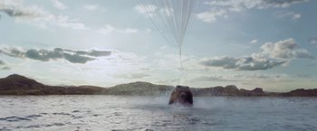 Movie still from “Gravity” (2013), directed by Alfonso Cuarón – A boat in a body of water with a parachutist attached to it; Extreme Wide shot, Overhead angle