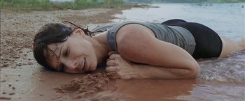 Movie still from “Gravity” (2013), directed by Alfonso Cuarón – A woman laying on the ground in the mud; Close Up shot, High angle
