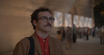 Movie still from “Her” (2013), directed by Spike Jonze – A man with a beard and mustache wearing glasses and a red shirt; Close Up shot, Over the shoulder angle