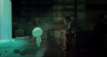 Movie still from “Her” (2013), directed by Spike Jonze – A man sitting on a chair in front of a lamp; Wide shot, Over the shoulder angle