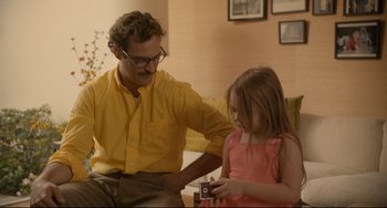 Movie still from “Her” (2013), directed by Spike Jonze – A man and a little girl looking at a camera; Medium shot, Over the shoulder angle