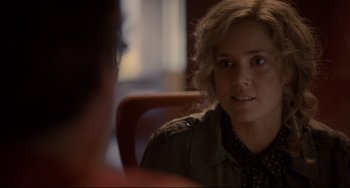 Movie still from “Her” (2013), directed by Spike Jonze – A woman sitting at a table looking at the camera; Close Up shot, Over the shoulder angle