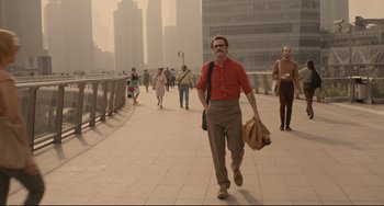 Movie still from “Her” (2013), directed by Spike Jonze – A man walking down a sidewalk in a city; Wide shot, Over the shoulder angle