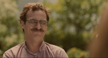 Movie still from “Her” (2013), directed by Spike Jonze – A person wearing glasses and smiling; Close Up shot, Over the shoulder angle