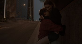 Movie still from “Her” (2013), directed by Spike Jonze – A woman is hugging a young boy on the side of the road; Medium shot, High angle