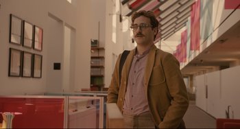 Movie still from “Her” (2013), directed by Spike Jonze – A man with a beard wearing a brown jacket and glasses; Medium shot, Low angle