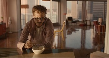 Movie still from “Her” (2013), directed by Spike Jonze – A man sitting at a table with a bowl of cereal; Medium shot, High angle