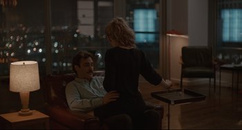 Movie still from “Her” (2013), directed by Spike Jonze – A man and a woman sitting in a chair in front of a window; Medium shot, High angle
