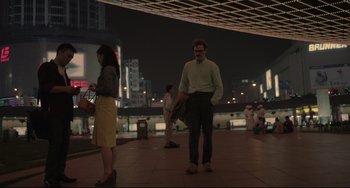 Movie still from “Her” (2013), directed by Spike Jonze – A man and a woman standing on a sidewalk at night; Extreme Wide shot, Over the shoulder angle