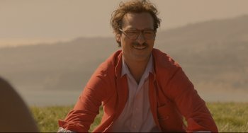 Movie still from “Her” (2013), directed by Spike Jonze – A man in a red jacket sitting on top of a hill; Close Up shot, Over the shoulder angle