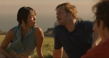 Movie still from “Her” (2013), directed by Spike Jonze – A man and a woman sitting in a grassy field; Close Up shot, Over the shoulder angle