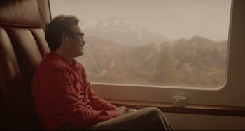 Movie still from “Her” (2013), directed by Spike Jonze – A man sitting in front of a window with a cup of coffee; Medium shot, Over the shoulder angle