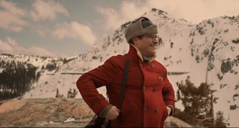 Movie still from “Her” (2013), directed by Spike Jonze – A man in a red coat standing in front of a snowy mountain; Medium shot, Low angle