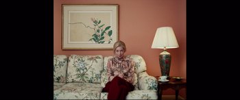 Movie still from “I, Tonya” (2017), directed by Craig Gillespie – A woman sitting on top of a couch in a living room; Medium shot, High angle