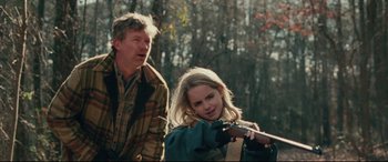 Movie still from “I, Tonya” (2017), directed by Craig Gillespie – A man and a woman in the woods with a rifle; Medium shot, Over the shoulder angle