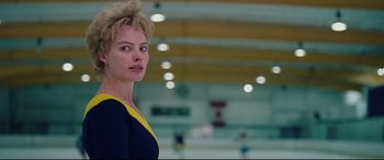 Movie still from “I, Tonya” (2017), directed by Craig Gillespie – A woman standing in an ice rink wearing a blue and yellow dress; Close Up shot, Low angle