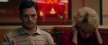 Movie still from “I, Tonya” (2017), directed by Craig Gillespie – A man and a woman sitting at a table in front of a neon sign; Close Up shot, Over the shoulder angle