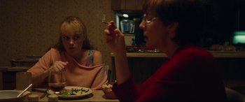 Movie still from “I, Tonya” (2017), directed by Craig Gillespie – Two women sitting at a table with a plate of food in front of them; Medium shot, Over the shoulder angle