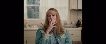Movie still from “I, Tonya” (2017), directed by Craig Gillespie – A woman is smoking a cigarette in a kitchen; Medium shot, High angle