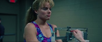 Movie still from “I, Tonya” (2017), directed by Craig Gillespie – A woman in a blue and purple floral shirt is looking at a scale; Close Up shot, Low angle