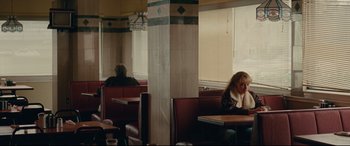 Movie still from “I, Tonya” (2017), directed by Craig Gillespie – A woman sitting at a booth in a restaurant; Medium shot, Over the shoulder angle