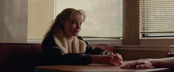 Movie still from “I, Tonya” (2017), directed by Craig Gillespie – A woman sitting at a table in front of a window; Medium shot, Over the shoulder angle