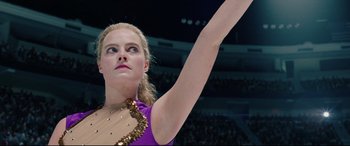 Movie still from “I, Tonya” (2017), directed by Craig Gillespie – A female figure skater in a purple dress is raising her arm; Close Up shot, Low angle