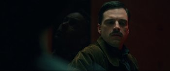 Movie still from “I, Tonya” (2017), directed by Craig Gillespie – A man with a mustache is looking at the camera; Close Up shot, Over the shoulder angle
