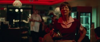 Movie still from “I, Tonya” (2017), directed by Craig Gillespie – A woman is holding a jar in her hand; Medium shot, Over the shoulder angle