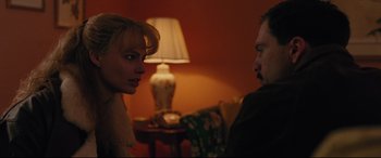 Movie still from “I, Tonya” (2017), directed by Craig Gillespie – A man and a woman in a room with a lamp; Close Up shot, Over the shoulder angle