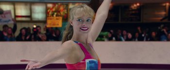 Movie still from “I, Tonya” (2017), directed by Craig Gillespie – A woman in a pink and blue top is smiling; Close Up shot, Low angle