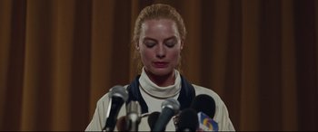Movie still from “I, Tonya” (2017), directed by Craig Gillespie – A woman standing in front of microphones in a room; Close Up shot, Low angle