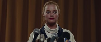 Movie still from “I, Tonya” (2017), directed by Craig Gillespie – A woman standing in front of microphones in a room; Close Up shot, Low angle