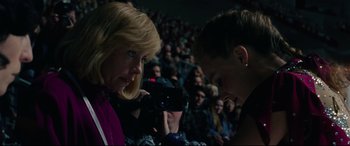 Movie still from “I, Tonya” (2017), directed by Craig Gillespie – A woman is taking a picture of another woman in front of an audience; Close Up shot, Over the shoulder angle