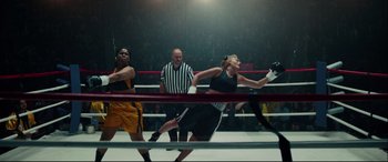 Movie still from “I, Tonya” (2017), directed by Craig Gillespie – A group of people that are in a boxing ring; Wide shot, Low angle