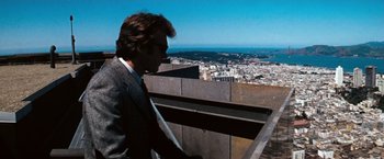 Movie still from “Dirty Harry” (1971), directed by Don Siegel – A man standing on a ledge looking at a city; Wide shot, Low angle
