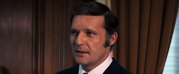 Movie still from “Dirty Harry” (1971), directed by Don Siegel – A person wearing a suit and tie; Close Up shot, High angle