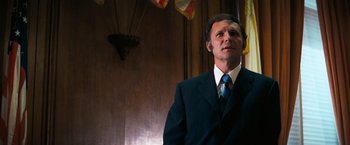 Movie still from “Dirty Harry” (1971), directed by Don Siegel – A man wearing a suit and tie in a room; Close Up shot, Low angle