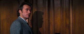 Movie still from “Dirty Harry” (1971), directed by Don Siegel – A man standing in front of a wooden wall; Close Up shot, Low angle